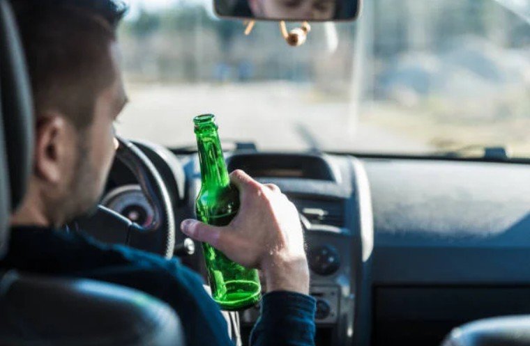 Man Drinking Beer while Driving a Car
