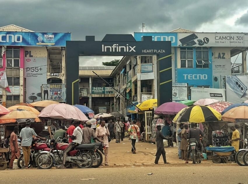A busy market with Infinix and TECNO sign posts