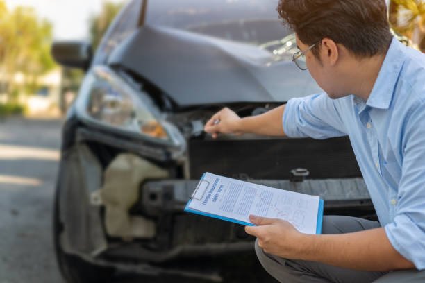 Insurance Agent evaluates a damaged vehicle