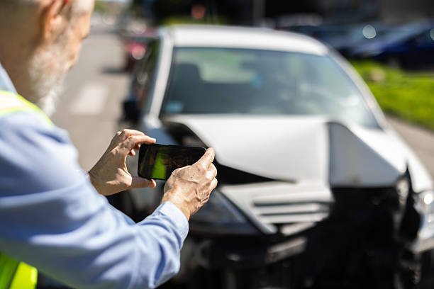 A Man taking photos of his crashed vehicle