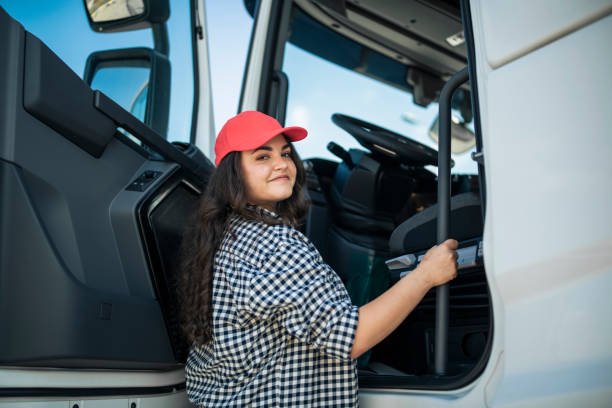 A Smiling Female Truck Driver Getting in the Truck.