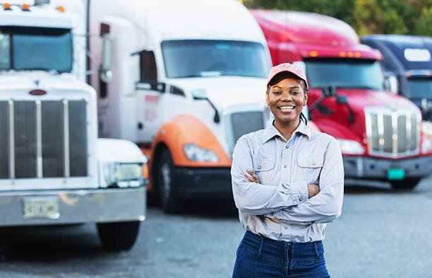 A smiling female semi-truck operator.
